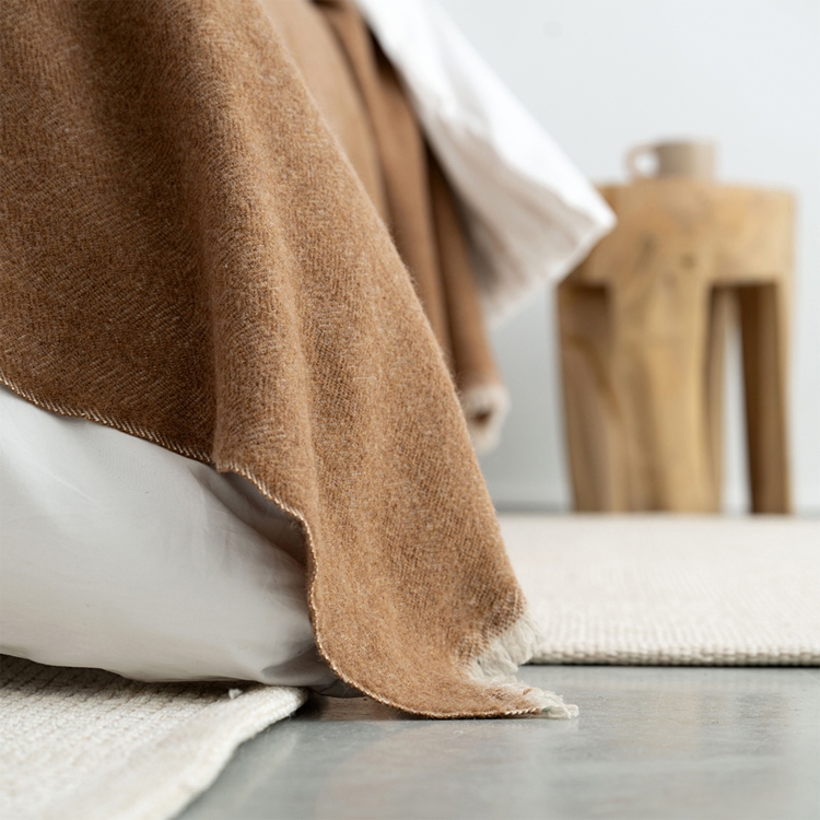 MOYHA Tagesdecke Herringbone Haselnussbraun 220x240 cm kombiniert mit weißen Kissen.
