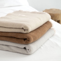 Dekorative MOYHA Wolldecke Herringbone Beige 130x170 cm im Schlafzimmer.